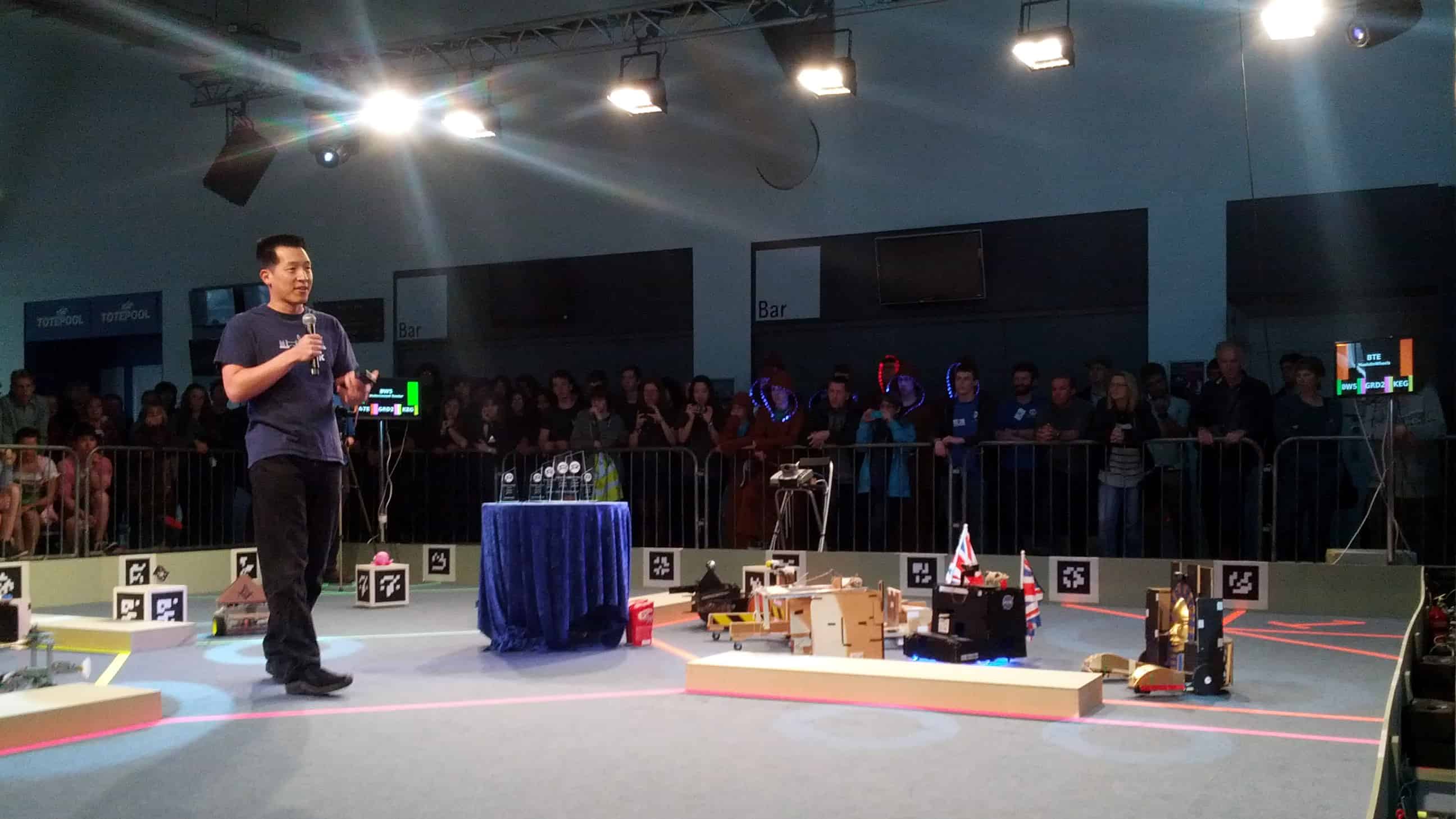 Prize giving ceremony at competition. Robots, awards and a presenter in an arena with competitors watching
